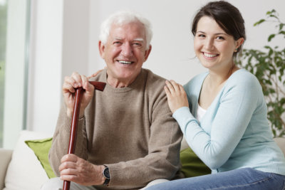 smiling old man holding a cane and smiling young woman