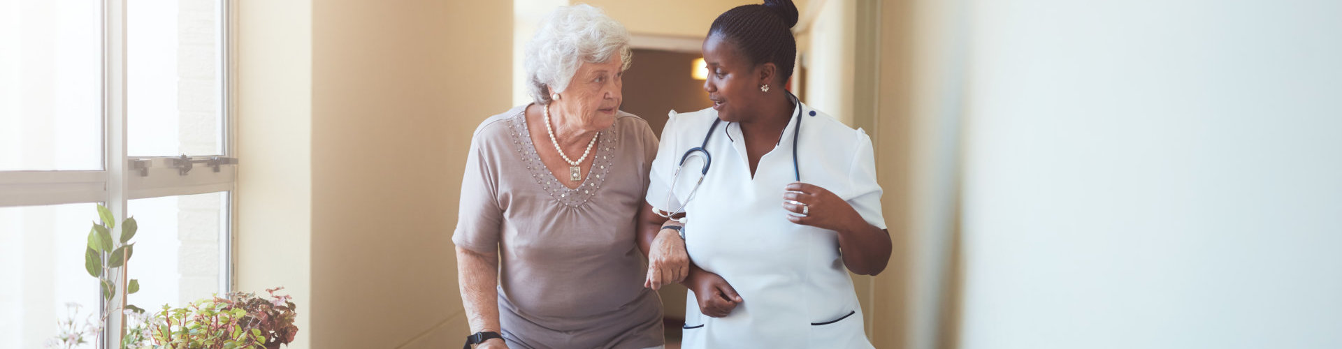 senior woman walking with her nurse